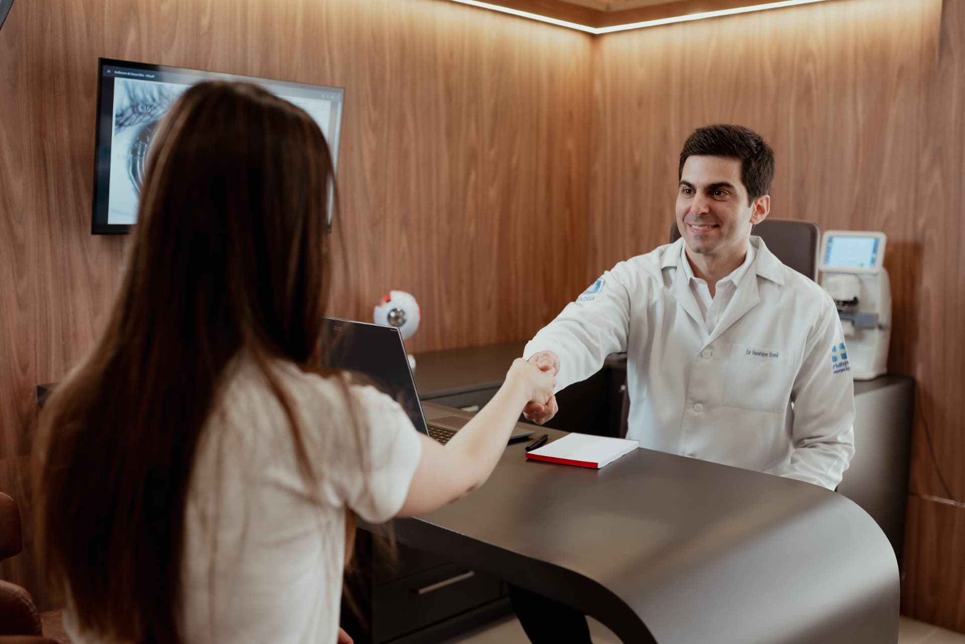 Dr. Henrique Doná cumprimentando uma paciente durante a consulta oftalmológica